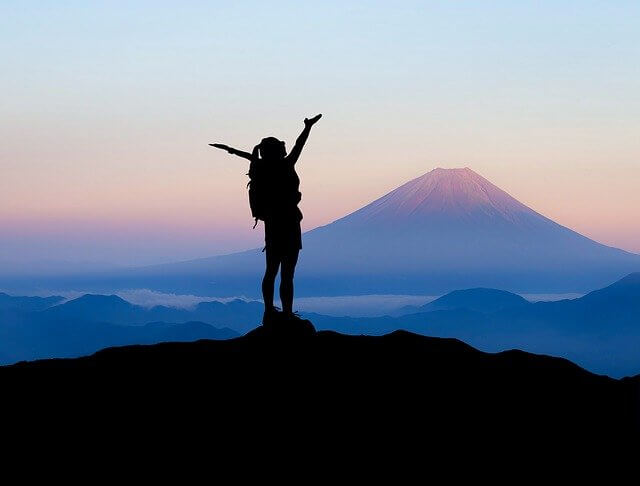 Woman successfully reaching mountain top