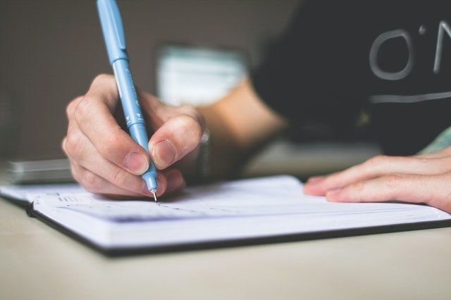 Person writing in book