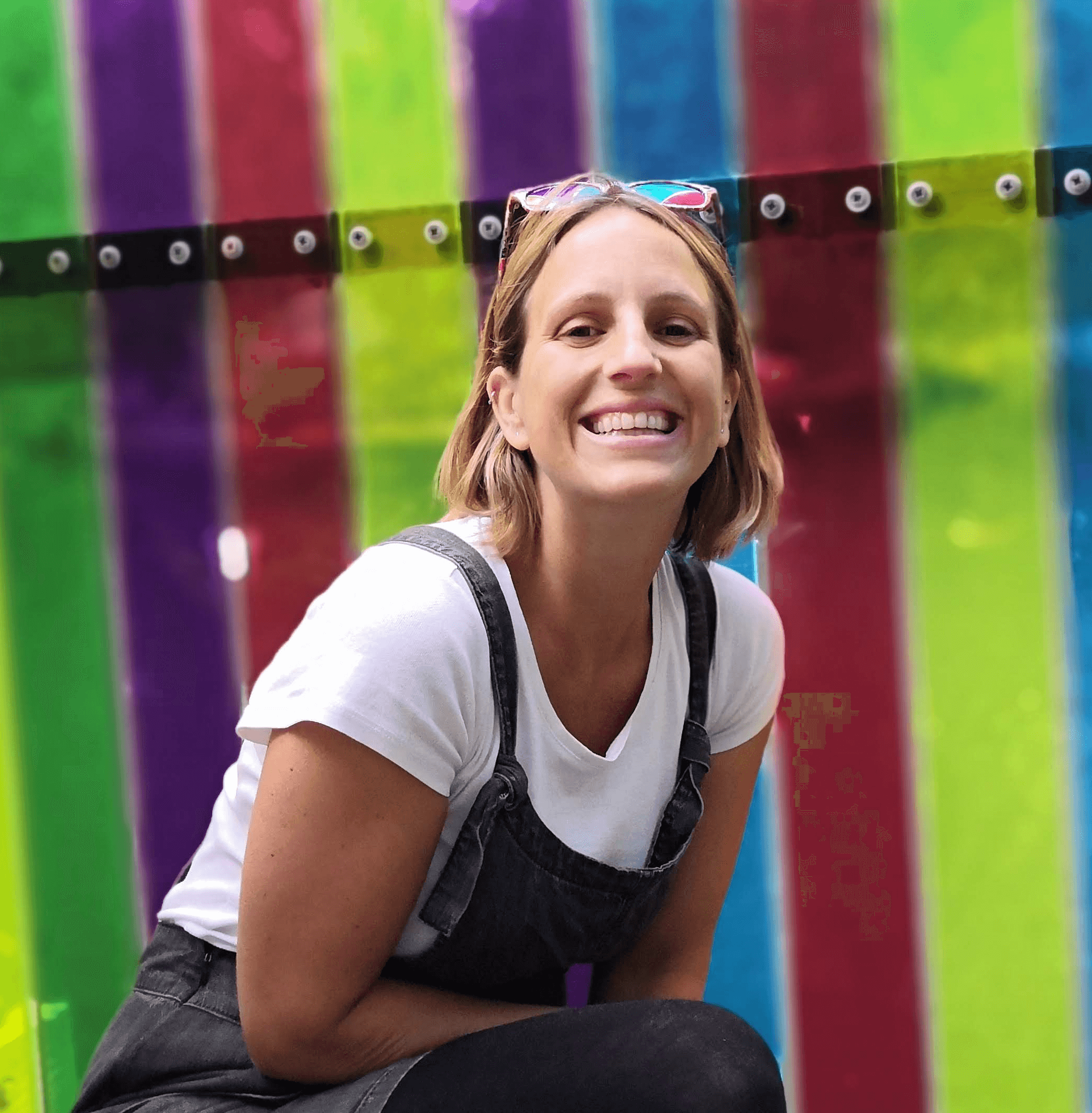 Woman smiling in front of rainbow striped background - Unclutter Nutter