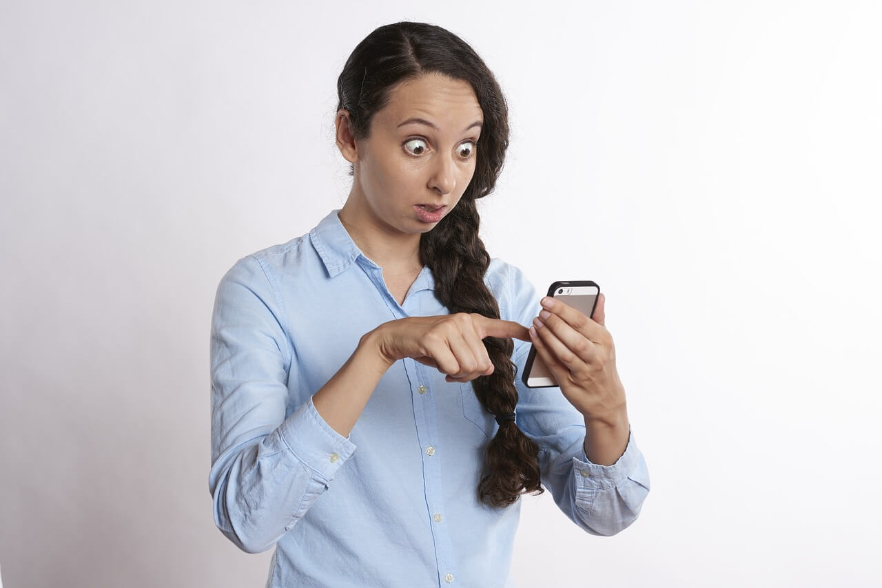 Surprised woman checking digital balance on phone