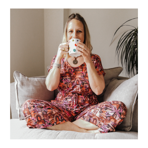 Martina Jay sitting on sofa holding a mug