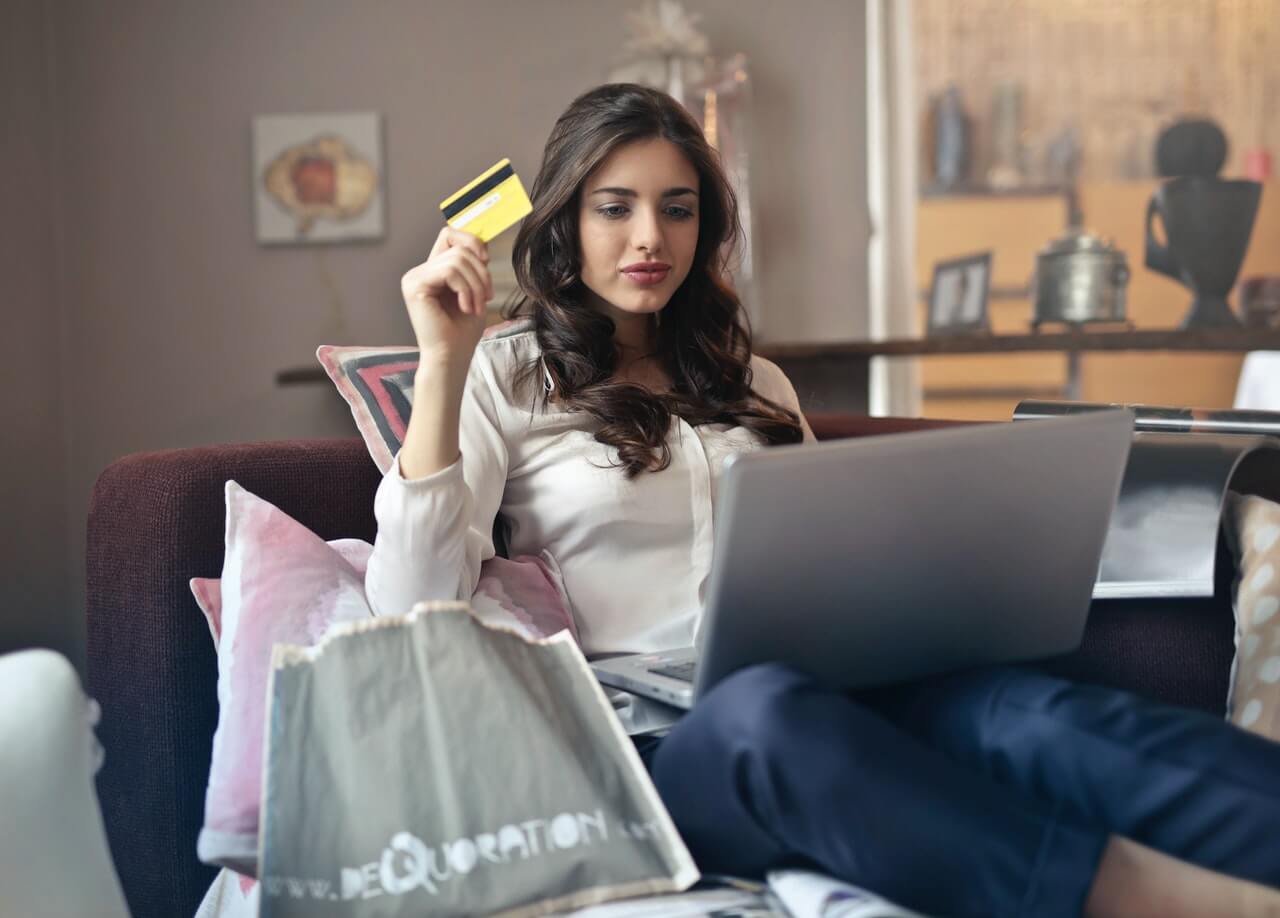 Woman holding gift card while shopping online
