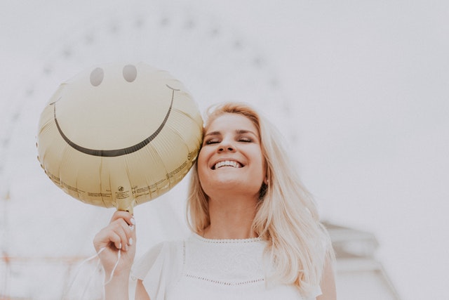 Woman happy holding a smiling balloon