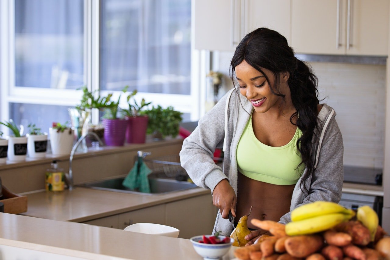 Woman cutting fruit preparing healthy morning breakfast