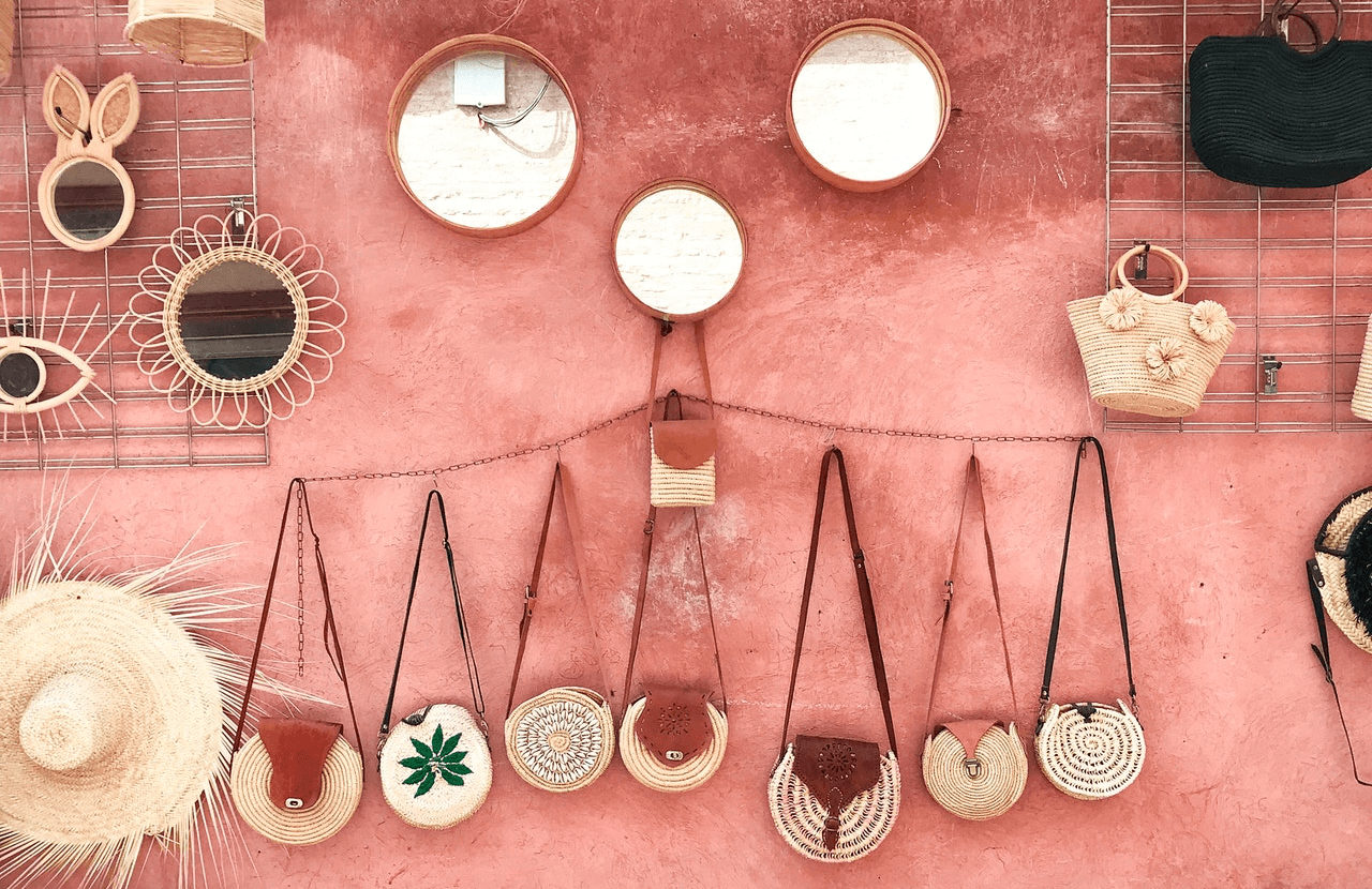 Coral painted wall with bags, mirrors, hats hanging nicely on scattered hooks and rails