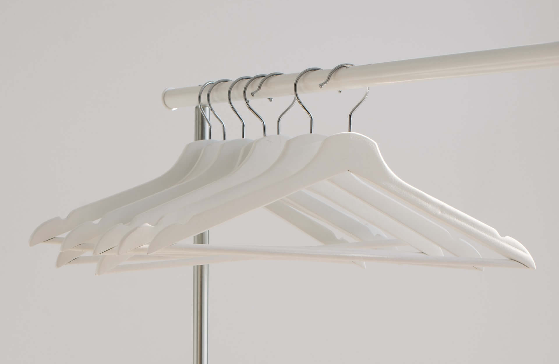 white wooden hangers on a clothes rail