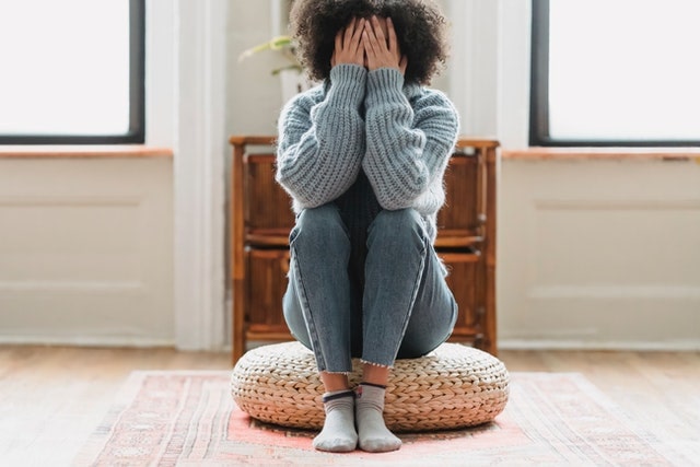 Woman sitting on a cushion upset with worrying